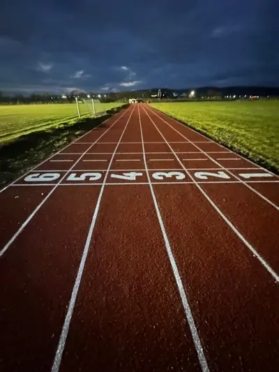 Pistă de atletism roșie cu marcaje World Athletics — lucrare #3, instalată de Atess Professional Flooring