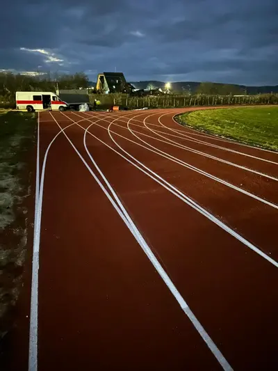 Pistă de atletism roșie cu marcaje World Athletics — lucrare #11, instalată de Atess Professional Flooring